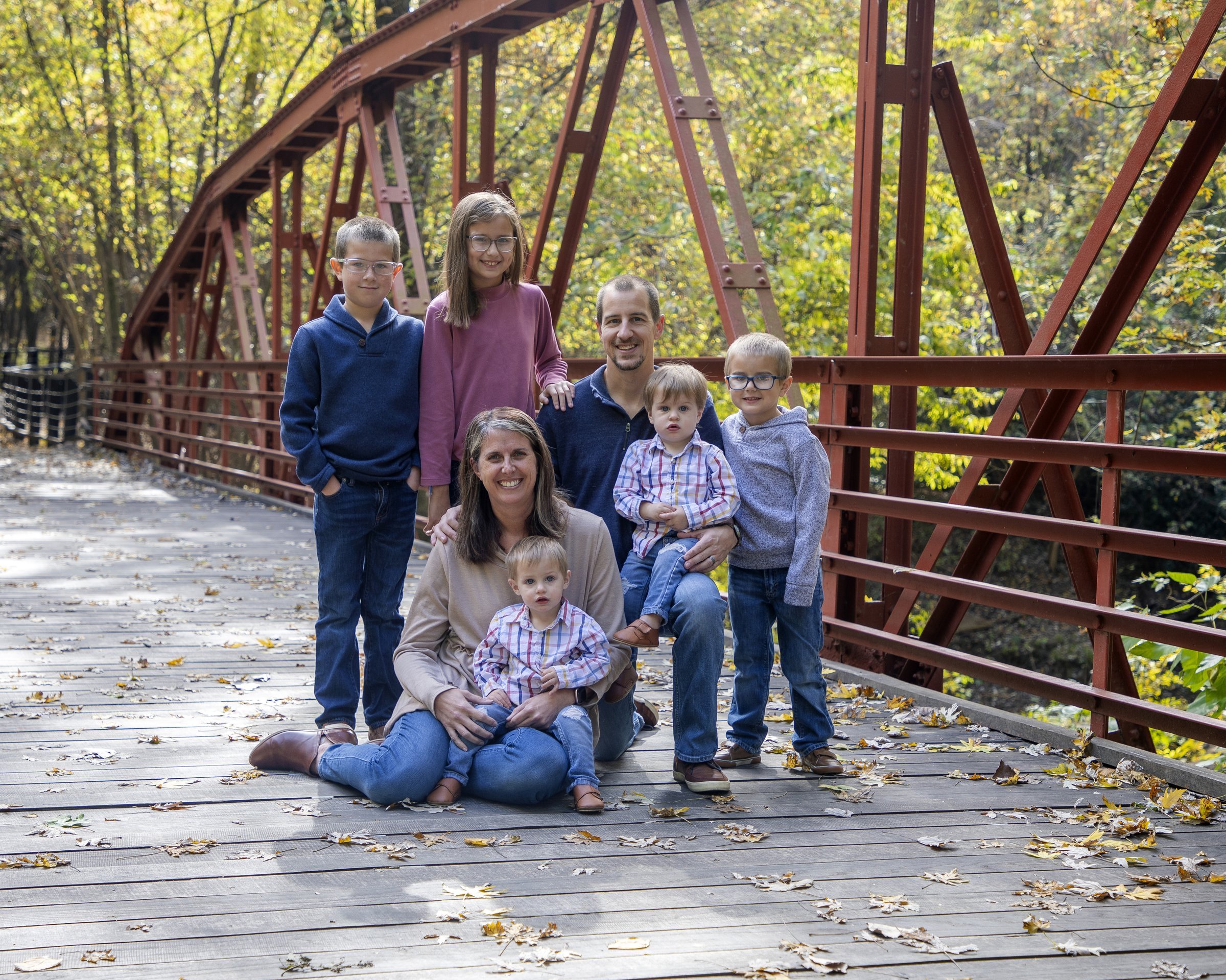 The Beach family on a bridge in autumn — Nathan, his wife, and their five children.
